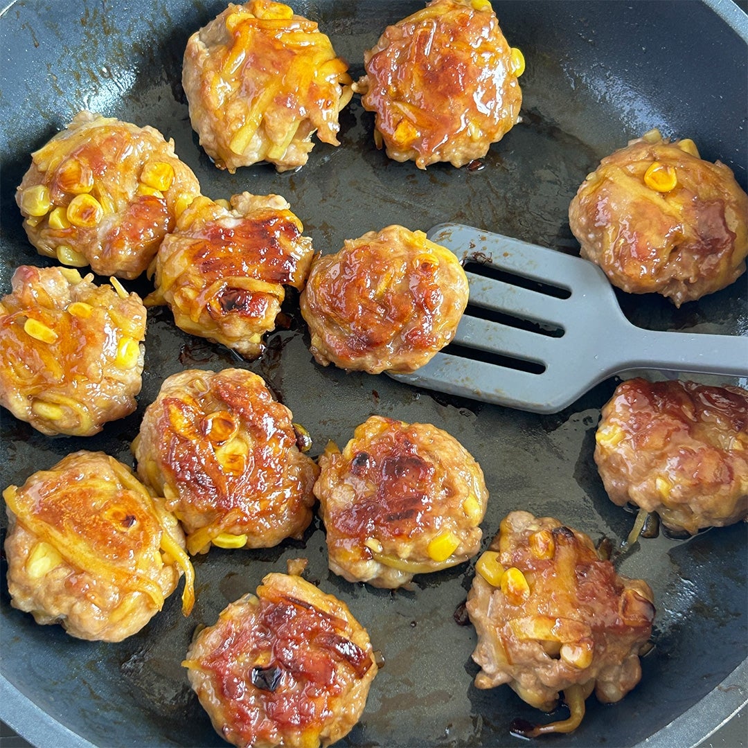 フライパンで焼かれたコーンとじゃがいも入りのつくね。