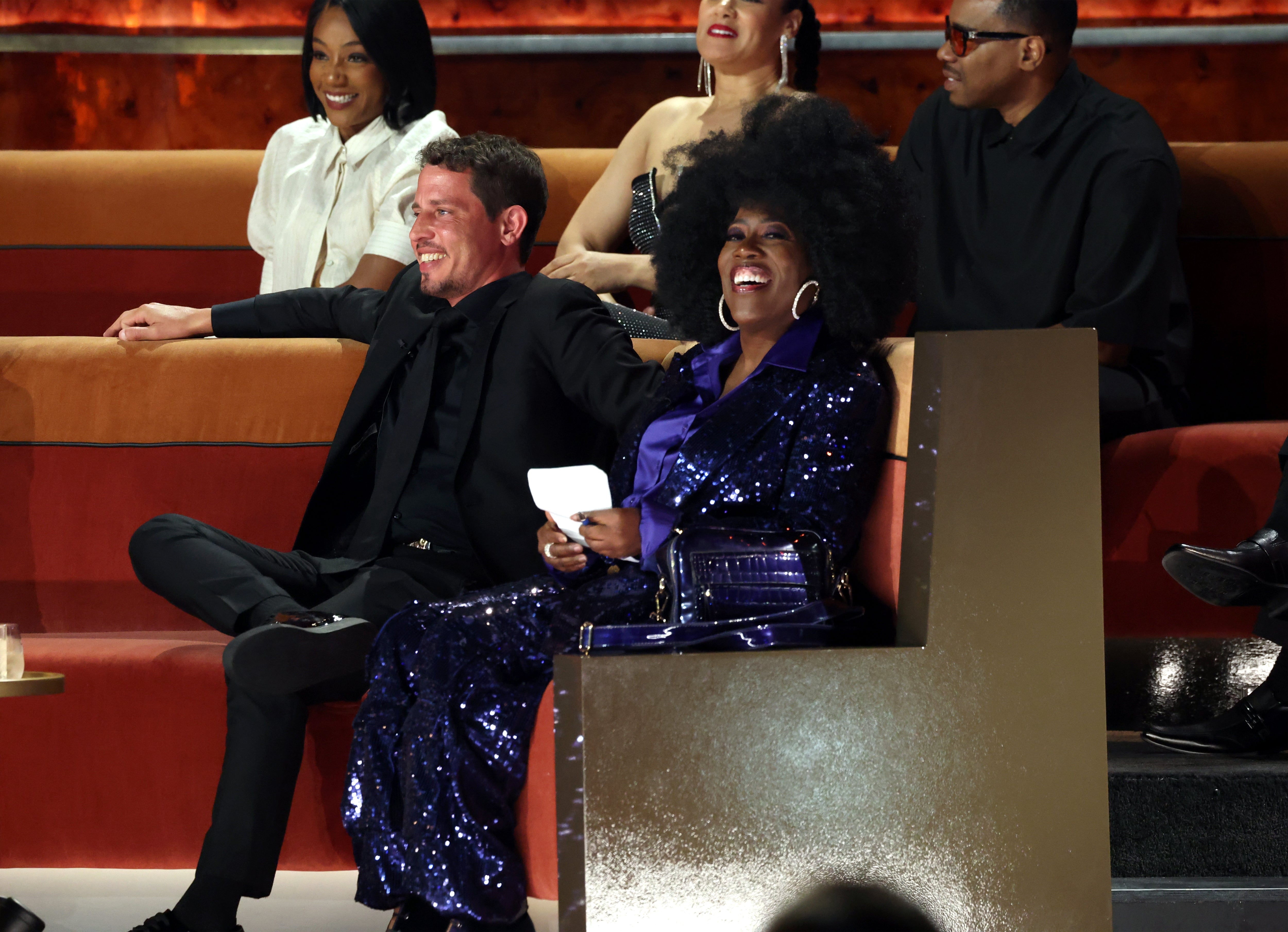Group of radical seated astatine an event. A pistillate successful a sequined formal and a antheral successful a suit beryllium together, smiling and enjoying the occasion