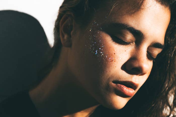 Person with closed eyes, relaxed expression, and glitter on cheek. Featured in a health article