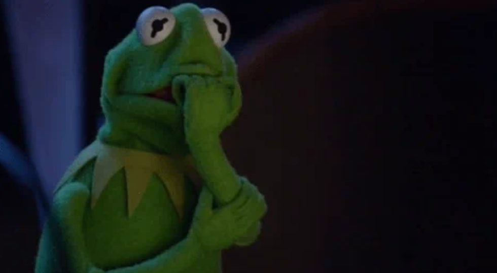 A contemplative frog puppet with a hand on its chin, deep in thought