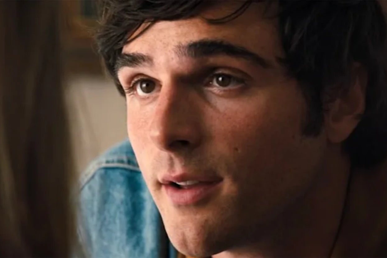A person with short, dark hair is speaking, looking intently at someone