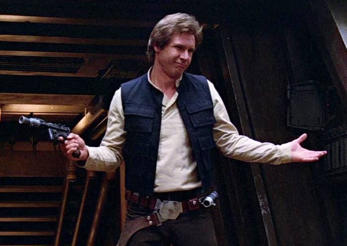 A character in a sci-fi movie scene, wearing a casual vest and holding a blaster, stands with arms open in a spaceship corridor