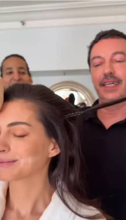 Two stylists hole   a woman, applying constitution  and styling her hair, successful  a nonrecreational  setting
