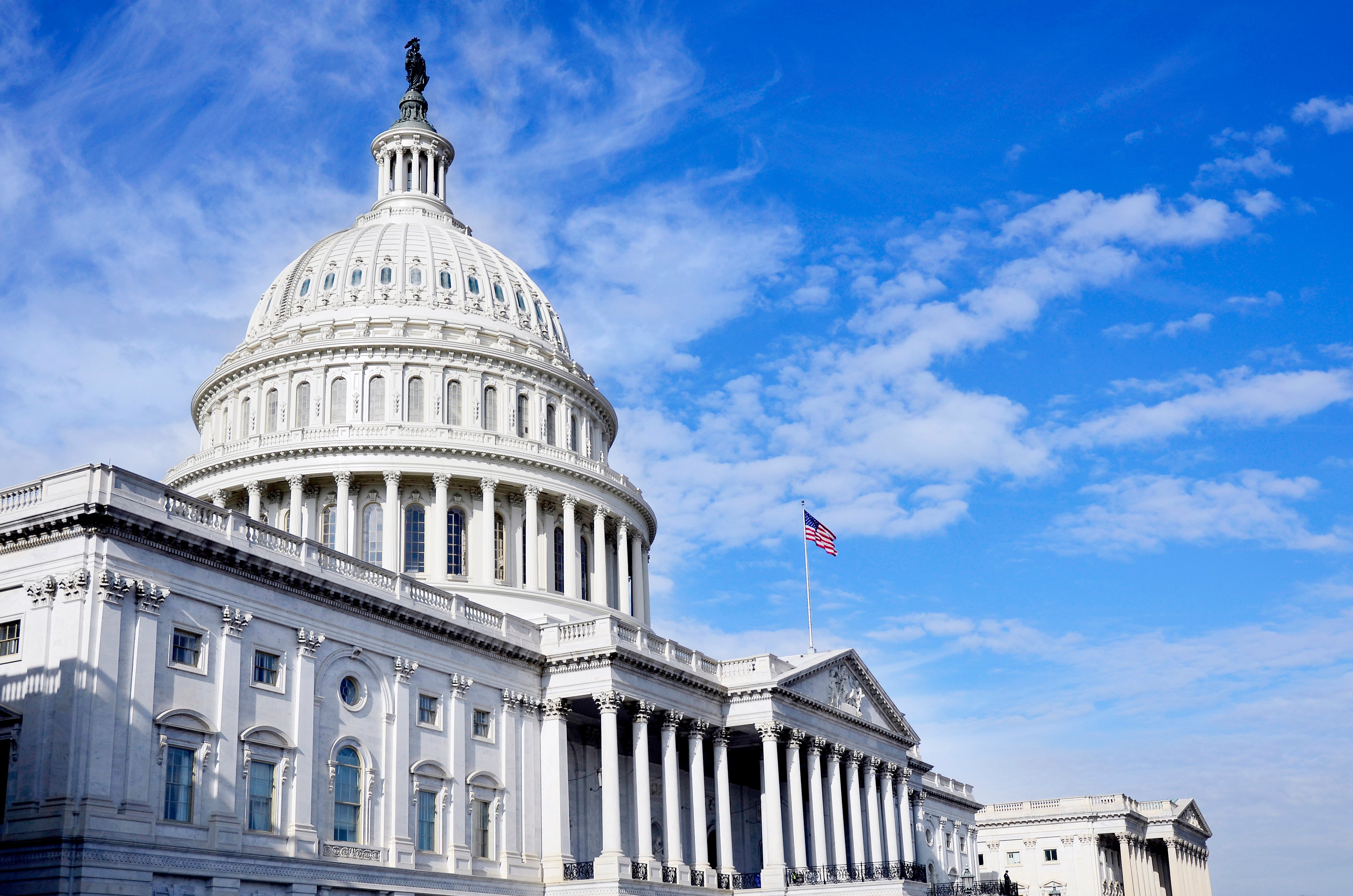 U.S. Capitol building with blue sky and clouds, symbolizing American government and politics