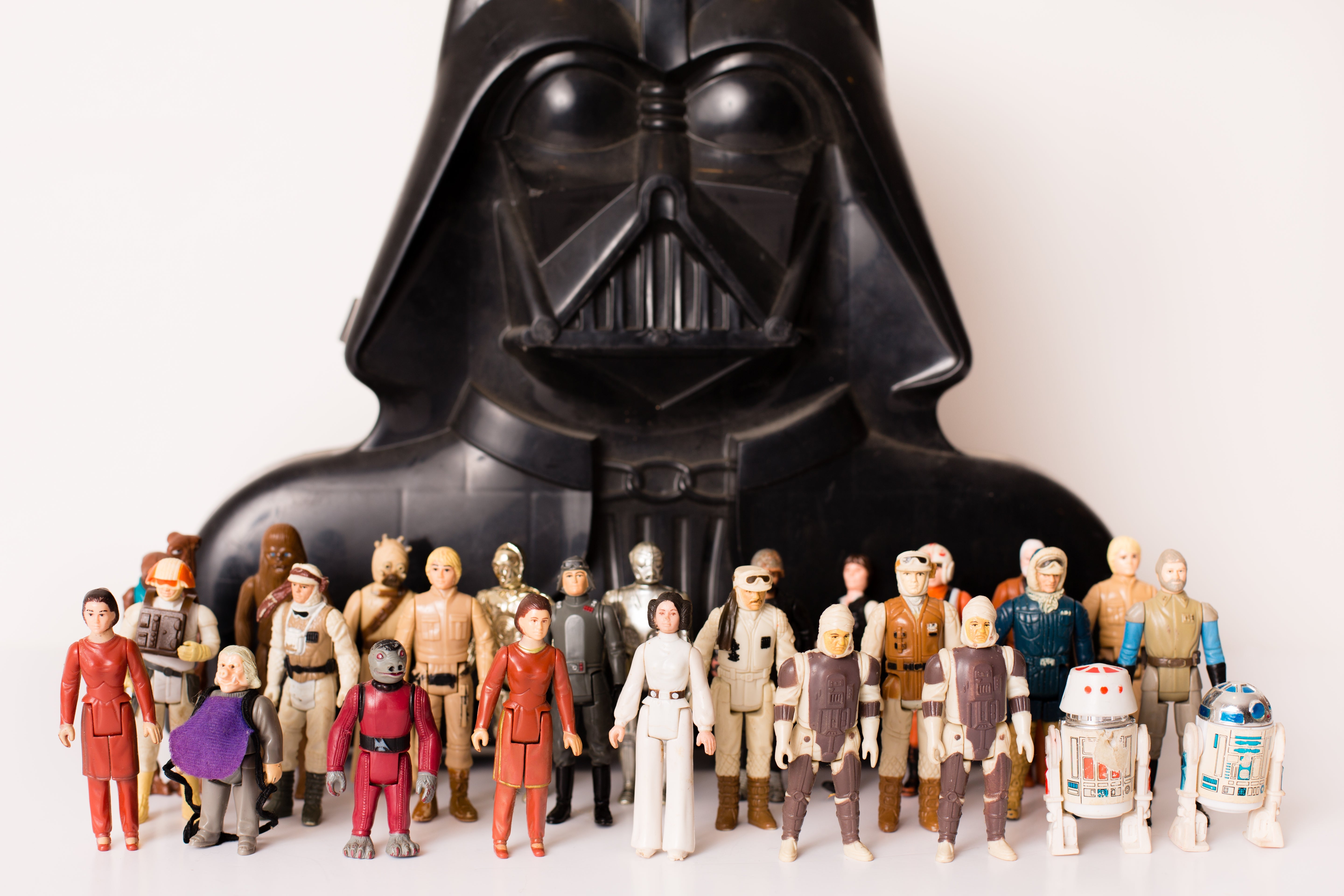 Star Wars action figures in front of a large Darth Vader bust, showcasing various iconic characters from the franchise