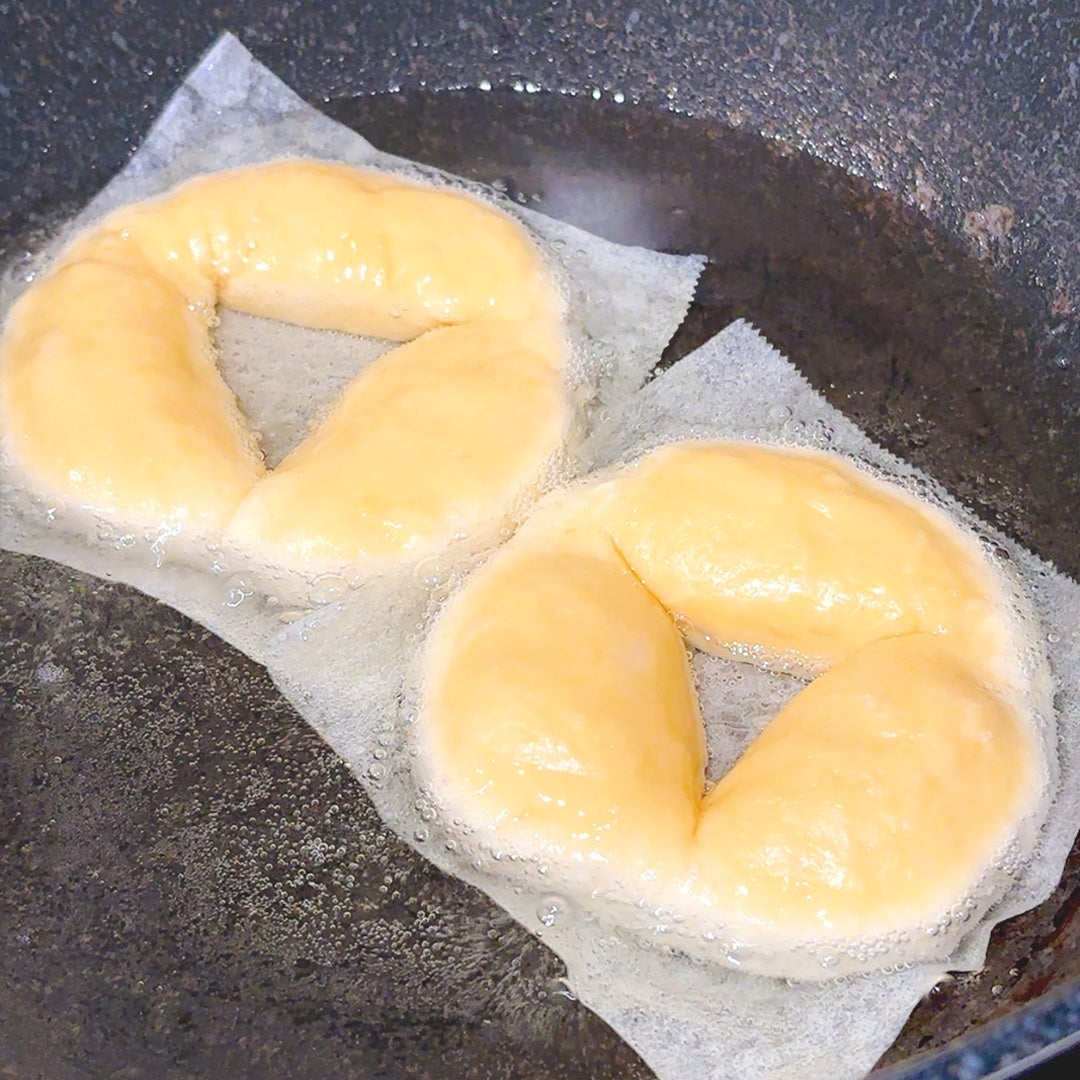 フライパンで揚げられているドーナツの生地。