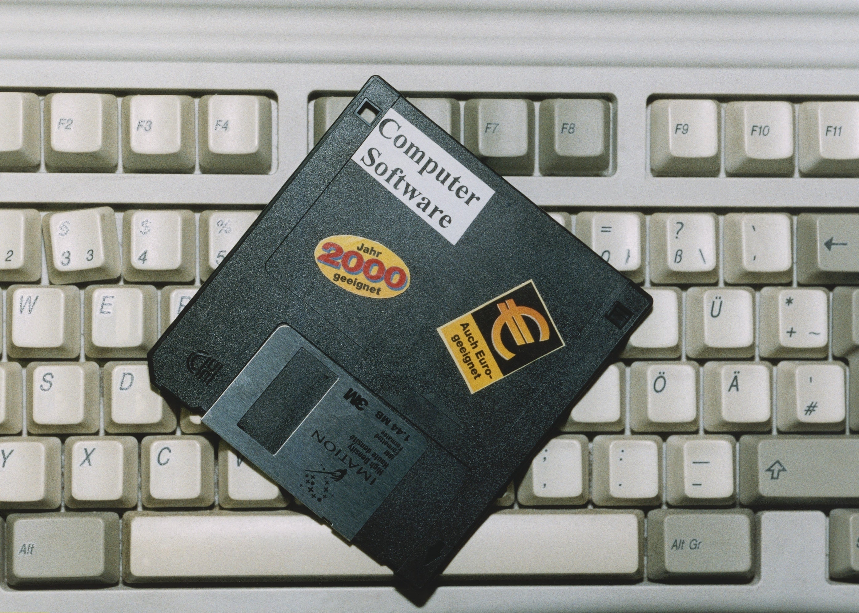 Floppy disk labeled "Computer Software, Jahr 2000" on a vintage keyboard, featuring a browser logo