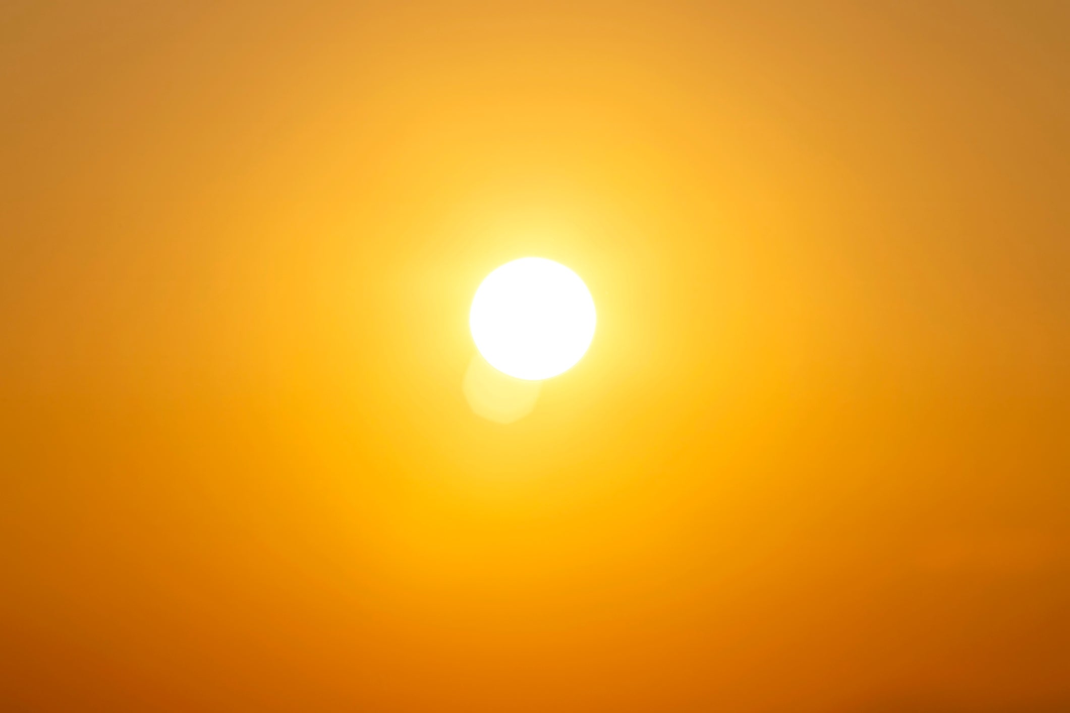 A bright sun in a clear sky creating a warm, glowing ambiance