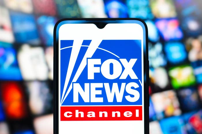 Fox News logo on a mobile screen, with a blurred background of various colorful app icons