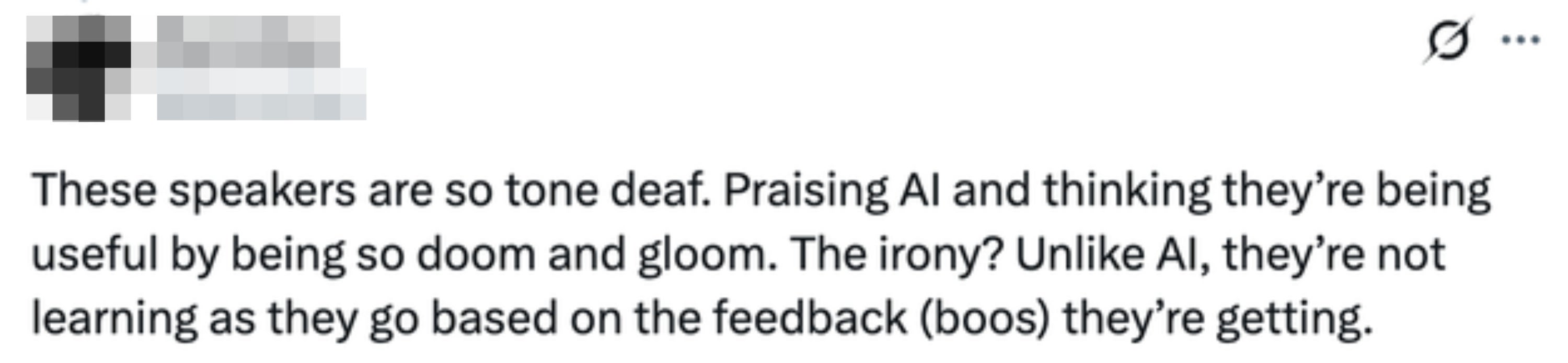 Tweet calls the speakers "tone deaf" and says "The irony? Unlike AI, they're not learning as they go based on the feedback (boos) they're getting"