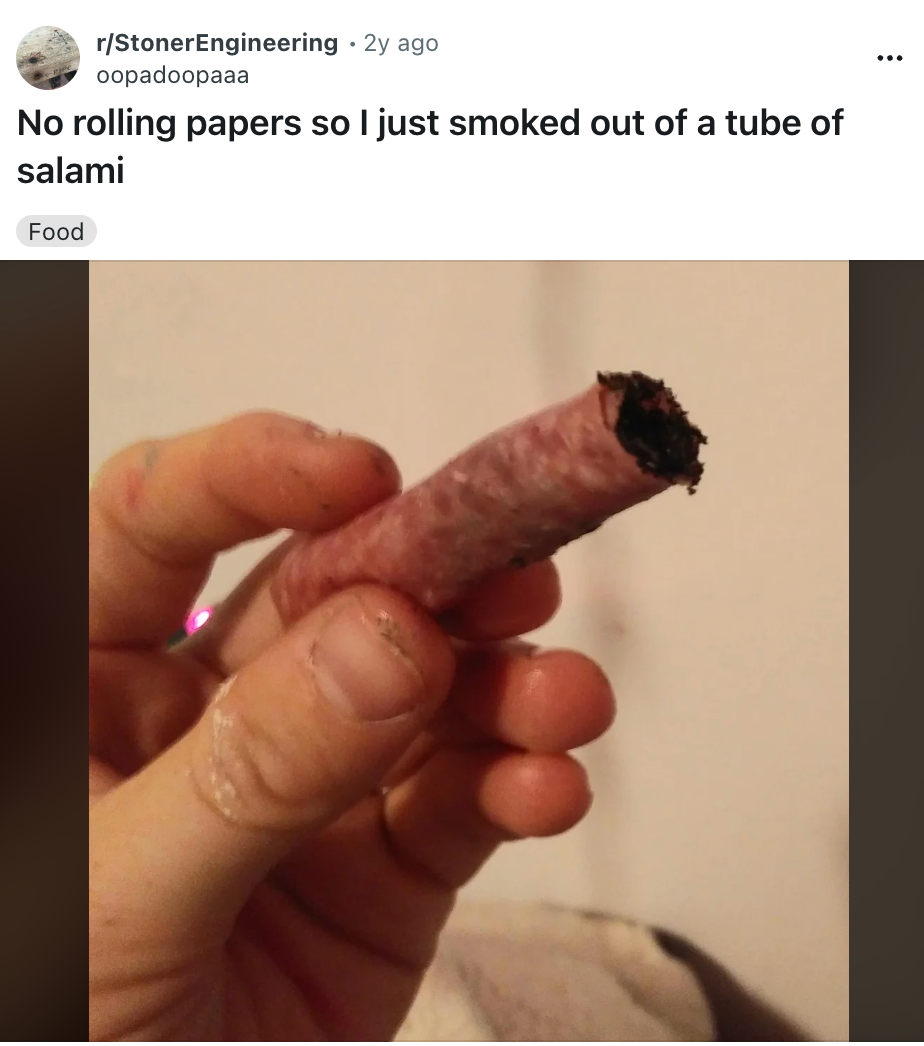 Person holding a piece of salami used as a makeshift smoking tool, as posted on a social media community