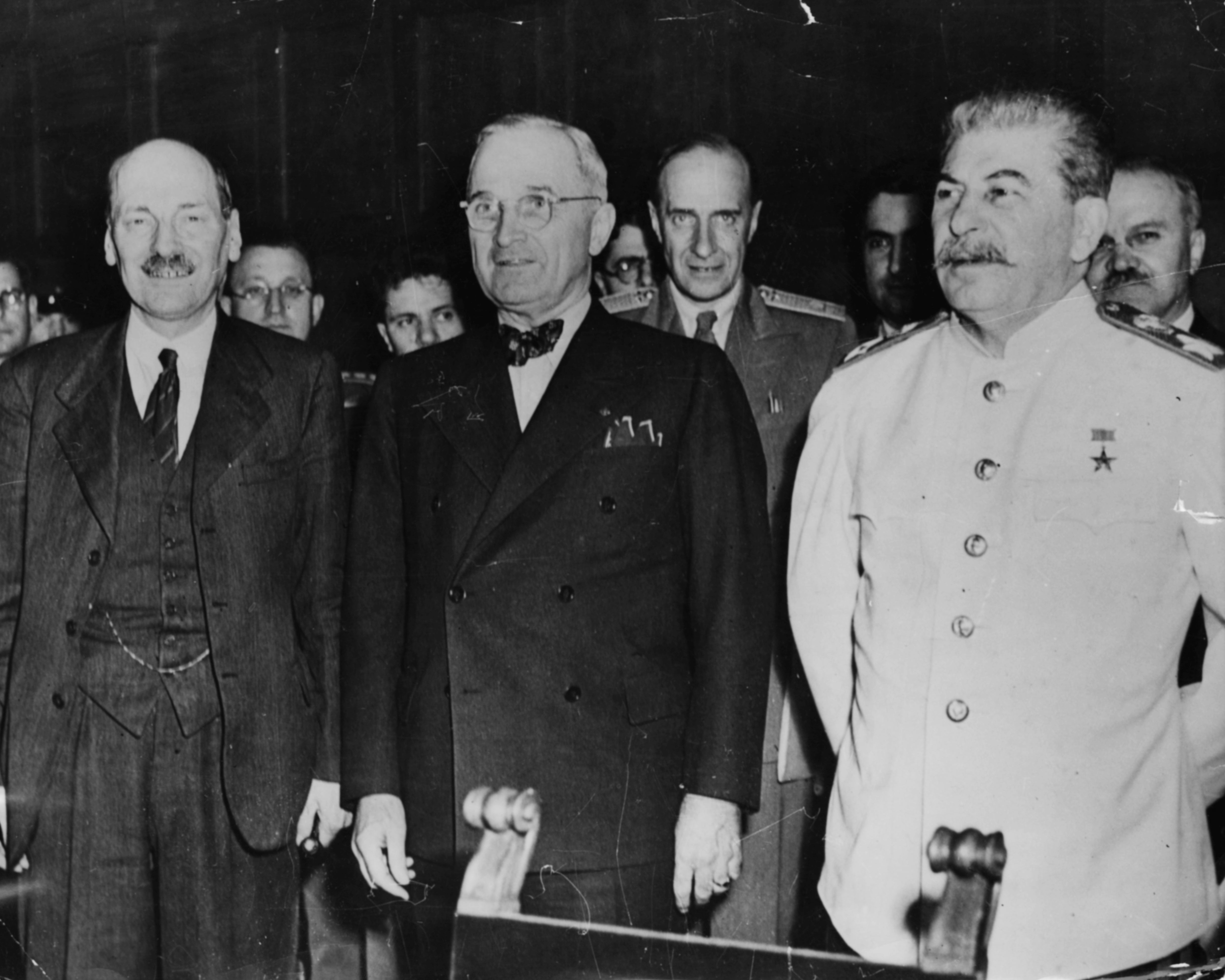 Three leaders from the mid-20th century stand together in formal attire, engaged in a historical event