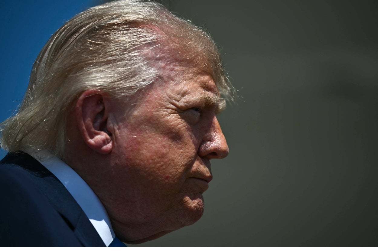 Side profile of a man with combed-back hair in a suit, looking serious