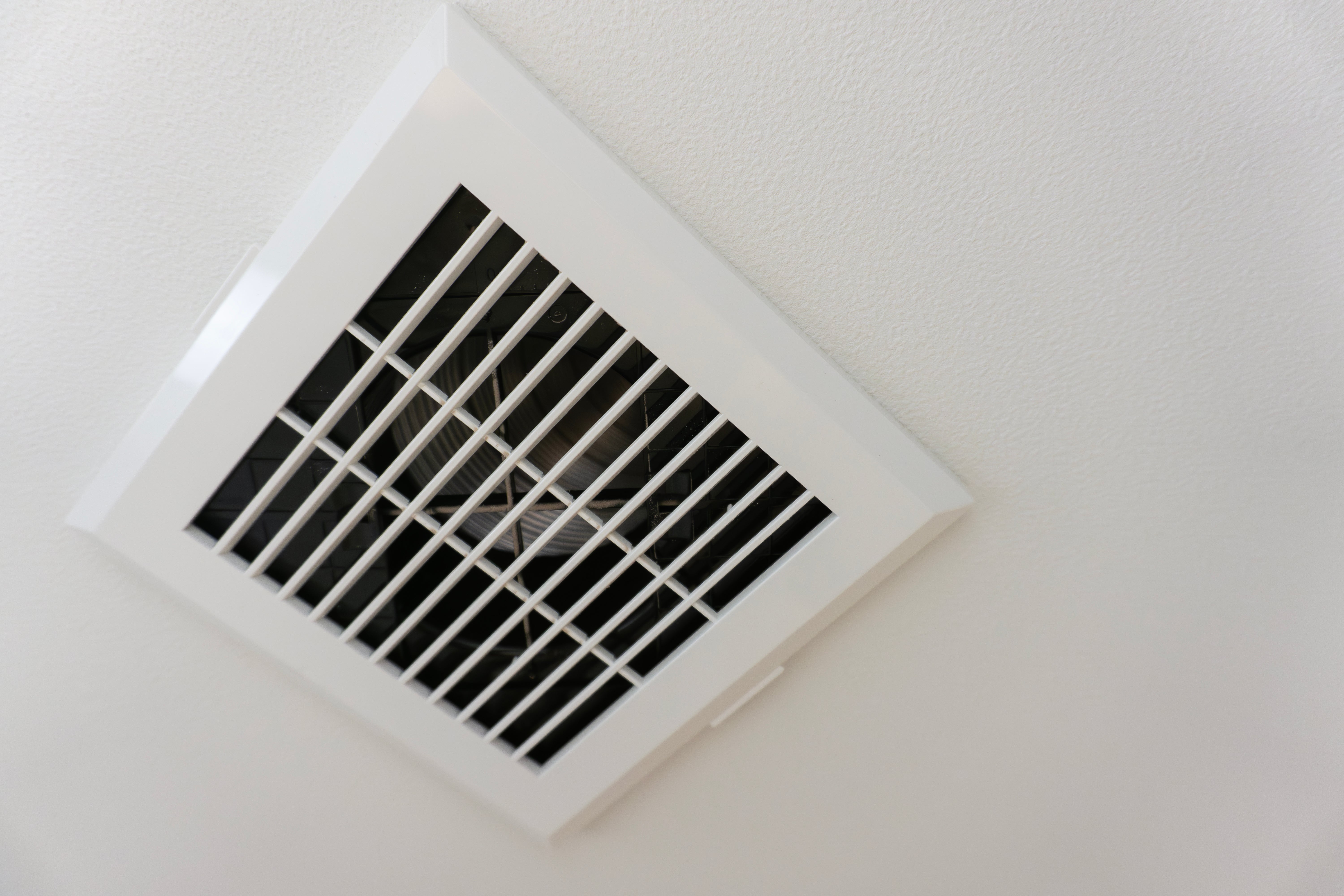 A ceiling air vent with horizontal and vertical slats is shown, allowing air to circulate in the room
