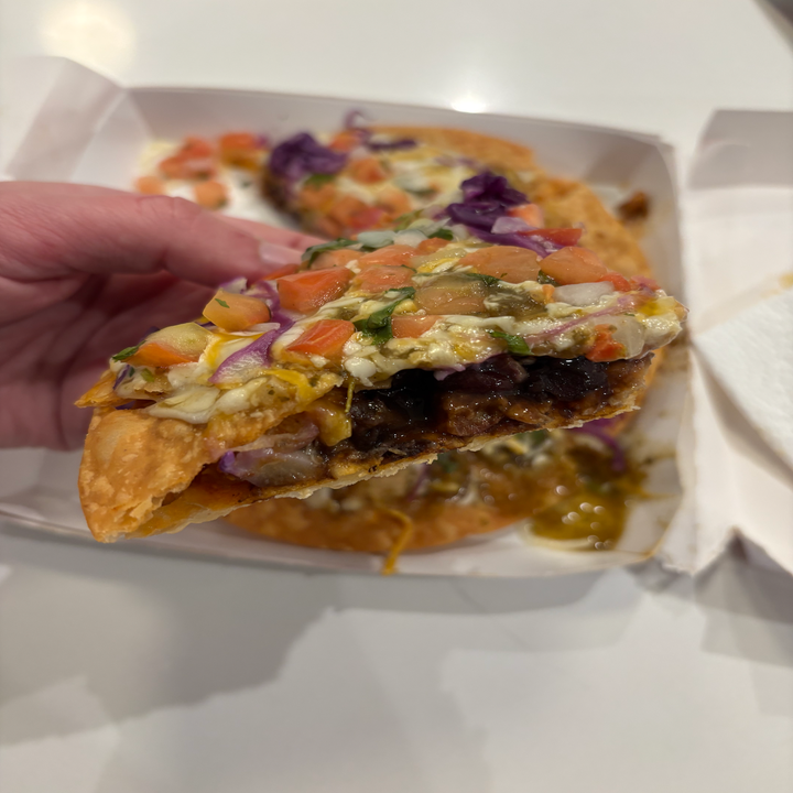Hand holding a slice of Taco Bell Cantina Chicken Mexican Pizza