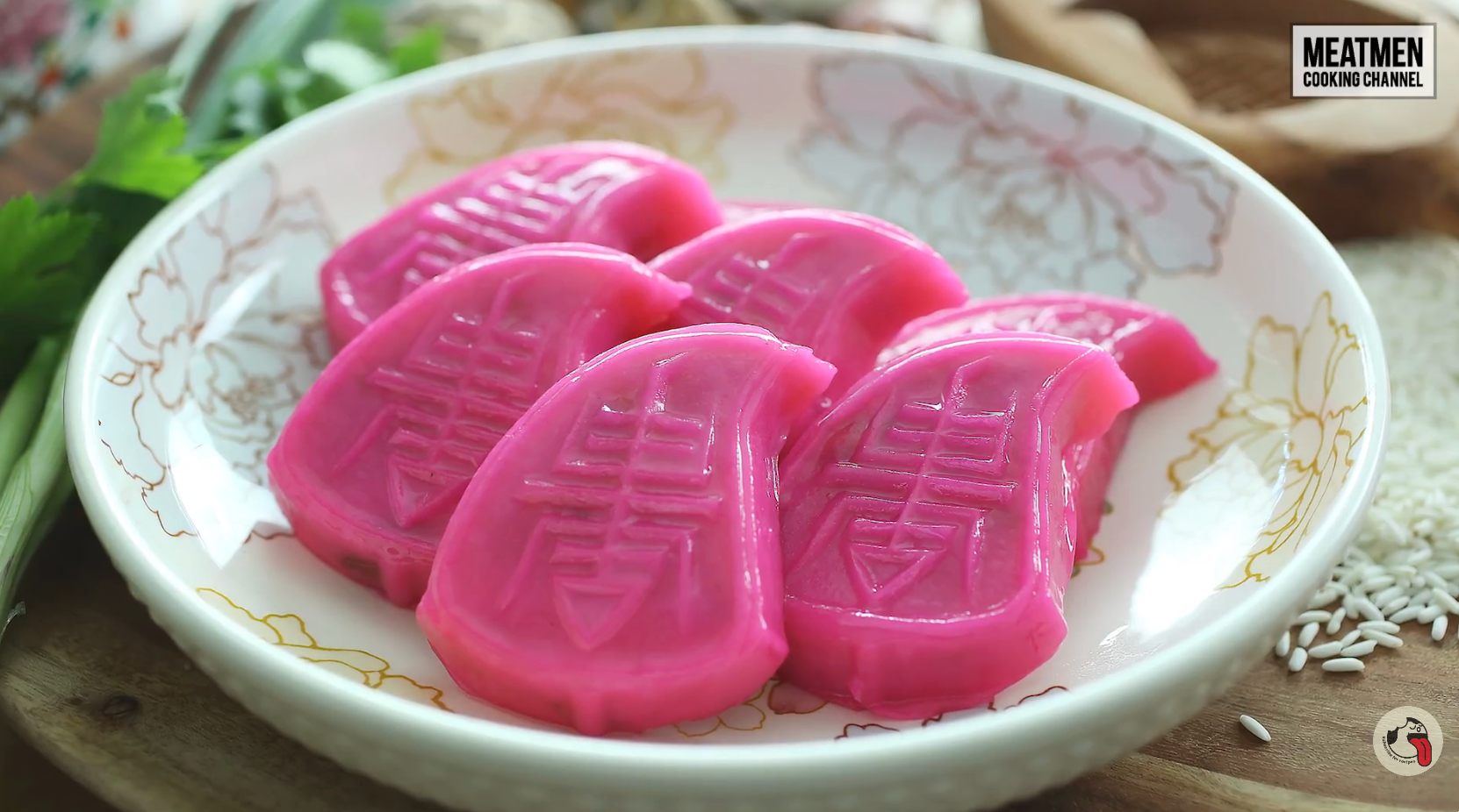 Plate of pinkish ang ku kueh, a accepted pastry with a turtle ammunition shape, connected a floral-patterned dish