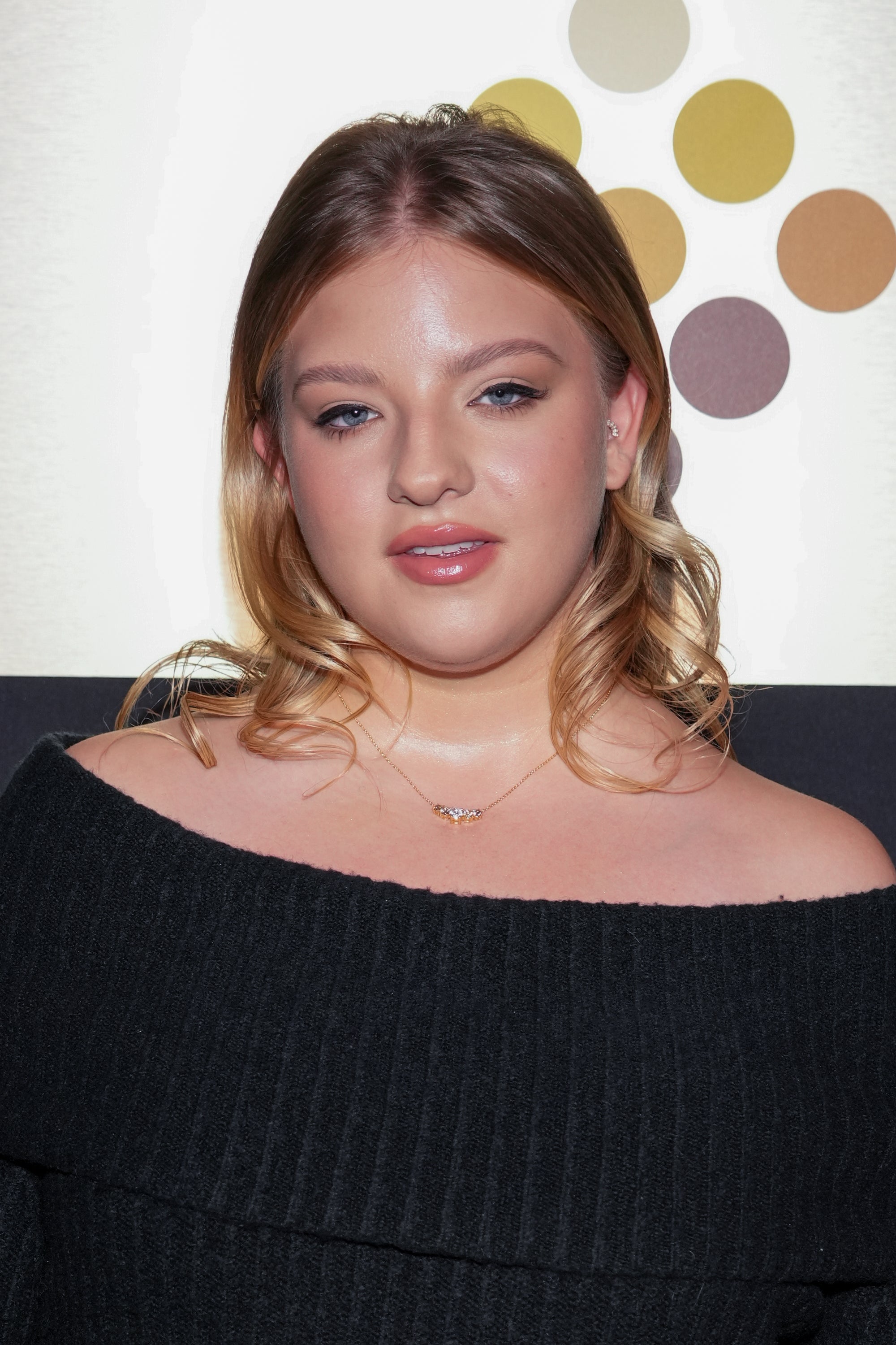 Francesca Scorsese wearing an off-the-shoulder ribbed top, posing confidently astatine  an event