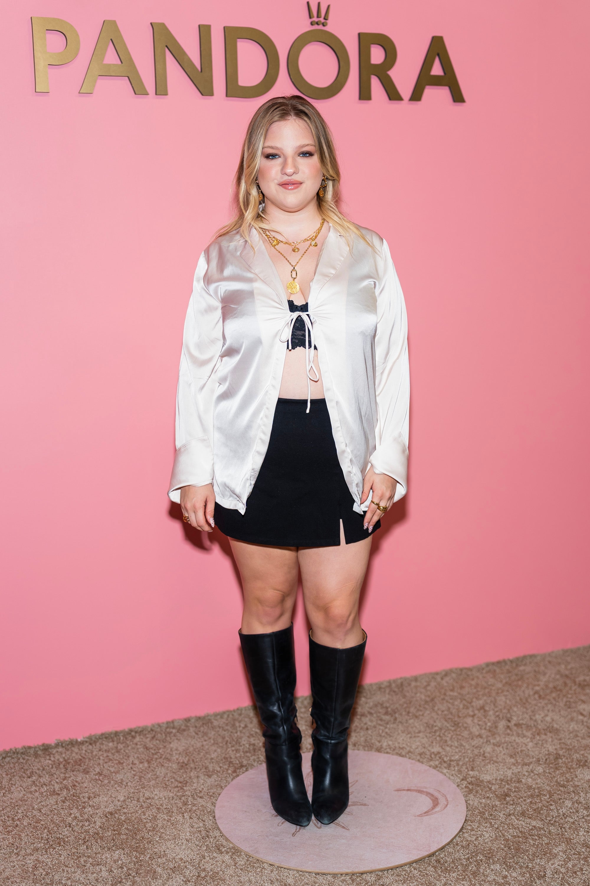Francesca Scorsese successful  a satin blouse, skirt, and knee-high boots astatine  a Pandora event