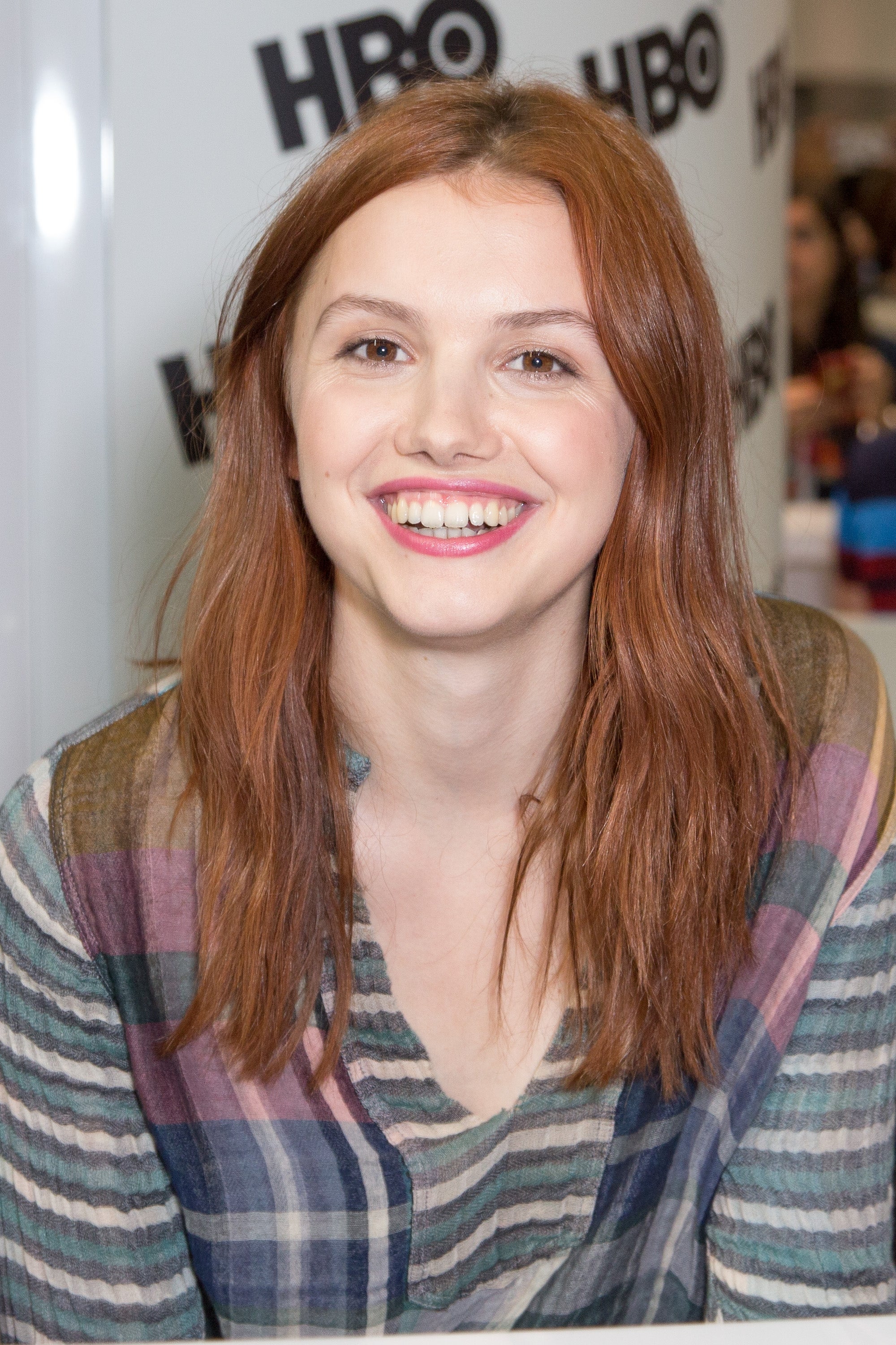 Person smiling astatine an lawsuit booth, wearing a plaid shirt