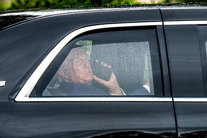 Person sitting successful  a car, looking retired  the window, holding a telephone  to their ear. Raindrops are disposable   connected  the window