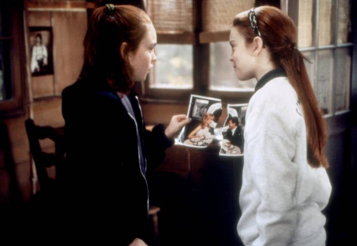 Lindsay Lohan arsenic  2  young girls successful  a compartment  comparing torn photographs, appearing funny  and engaged successful  conversation