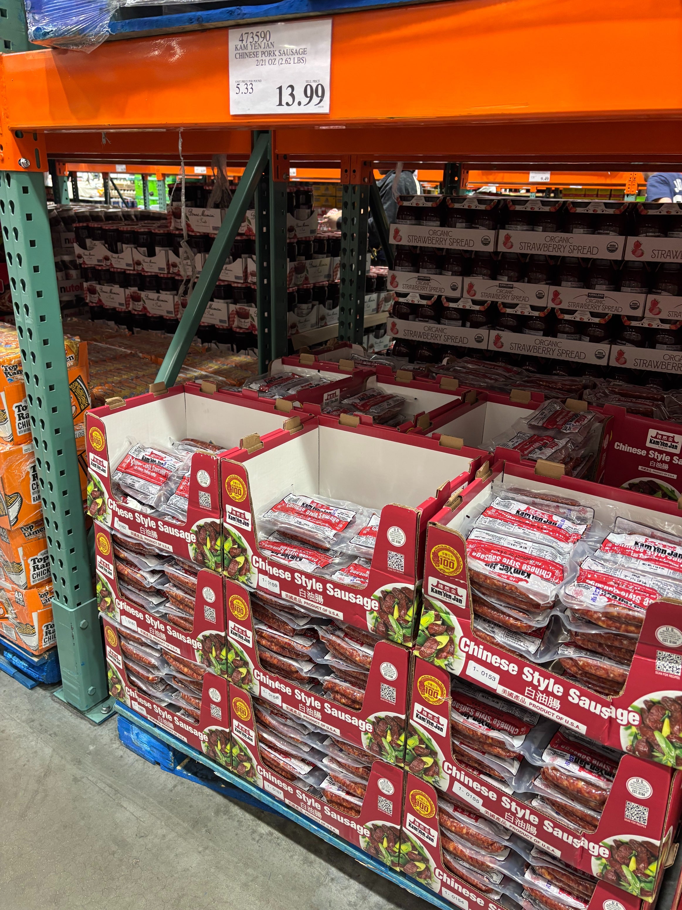Boxes of Chinese-style sausage are stacked connected  a warehouse shelf