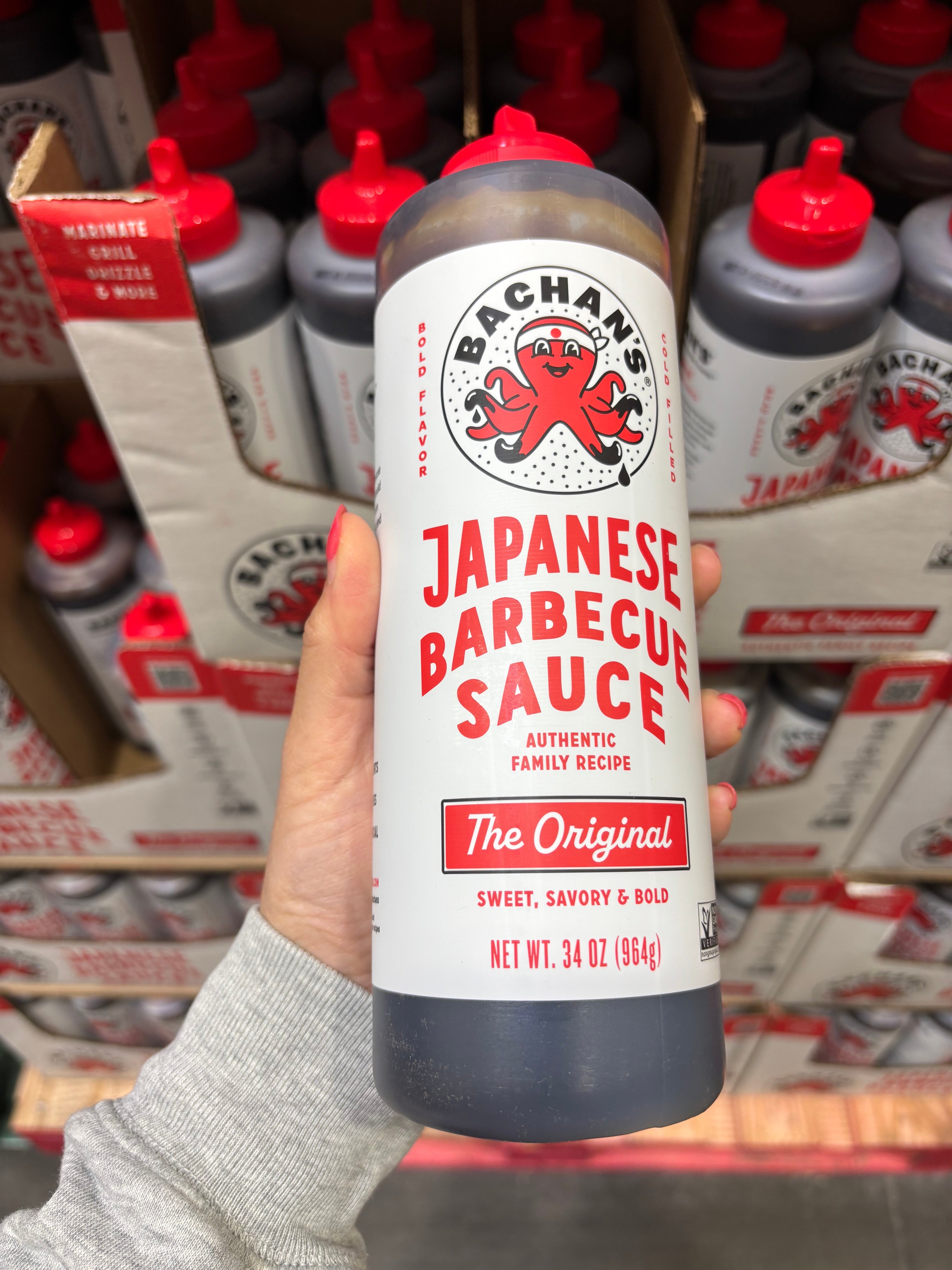 Hand holding a vessel  of sauce