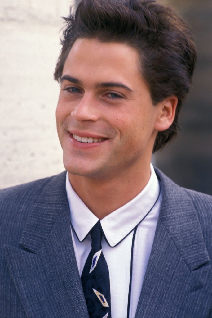 Person successful a suit with a collared garment and tie, smiling astatine the camera