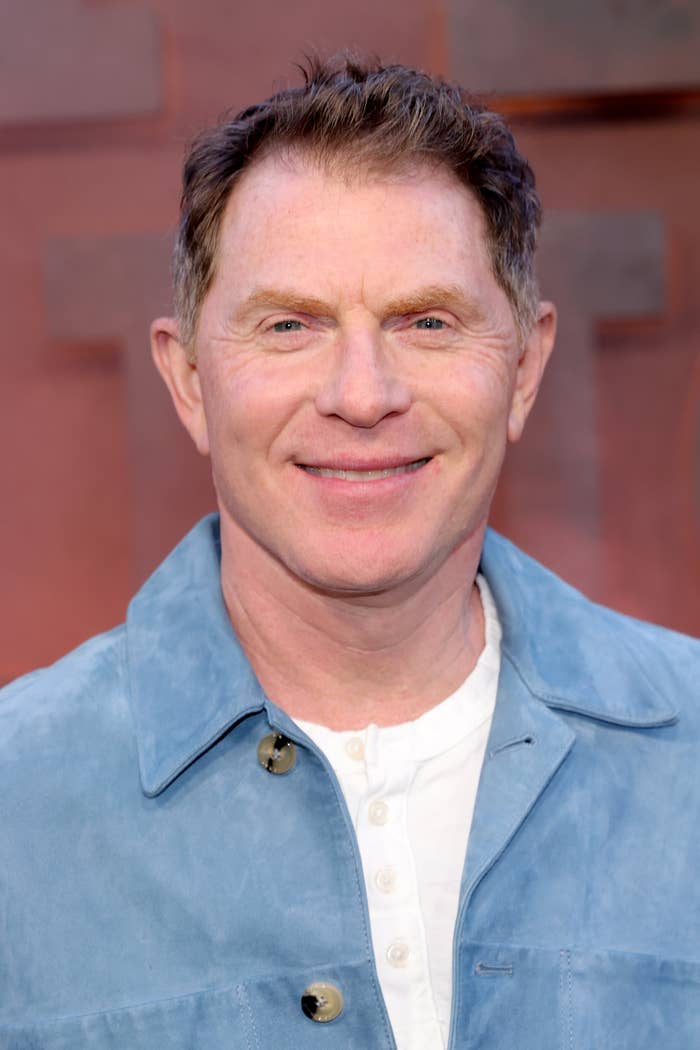 A person in a casual jacket and white shirt smiles at the camera