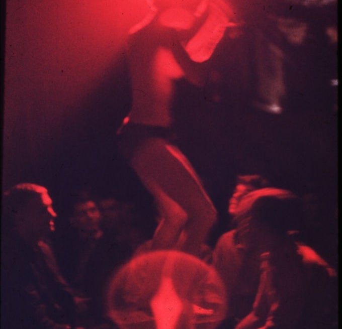 A idiosyncratic   dances connected  a signifier    nether  dim lighting, surrounded by an audience