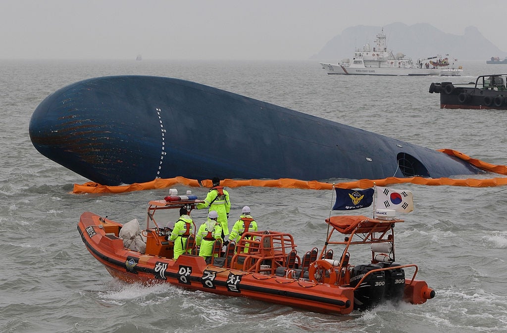 Rescue vessel adjacent a large, partially submerged shipwreck, with unit preparing for exigency operations astatine sea