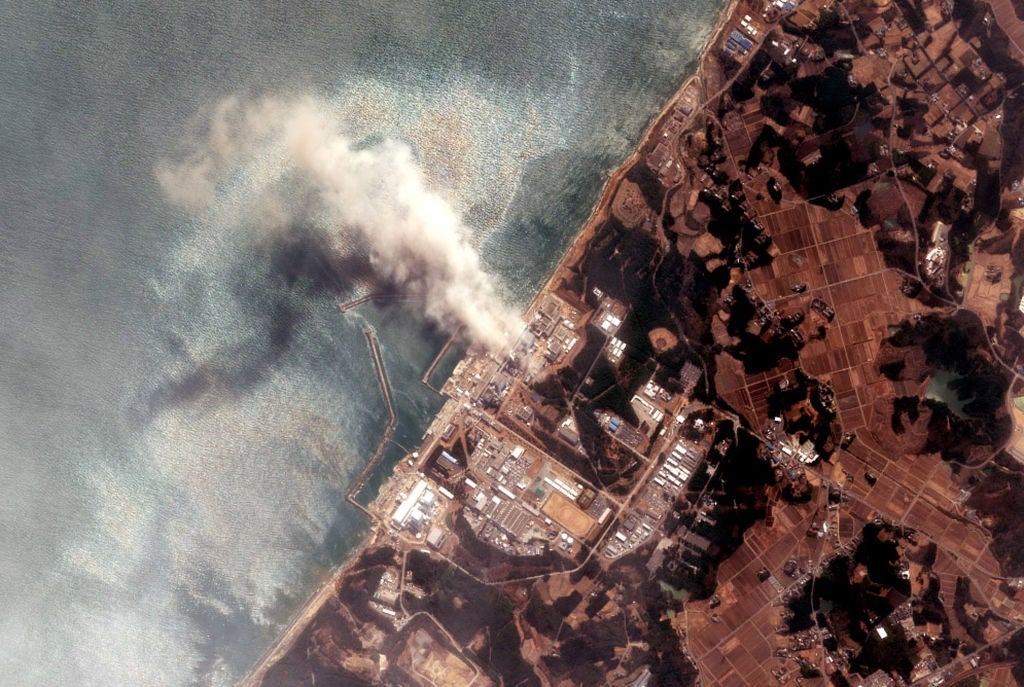Aerial presumption of a coastal concern country with fume rising from a facility, surrounded by onshore and water