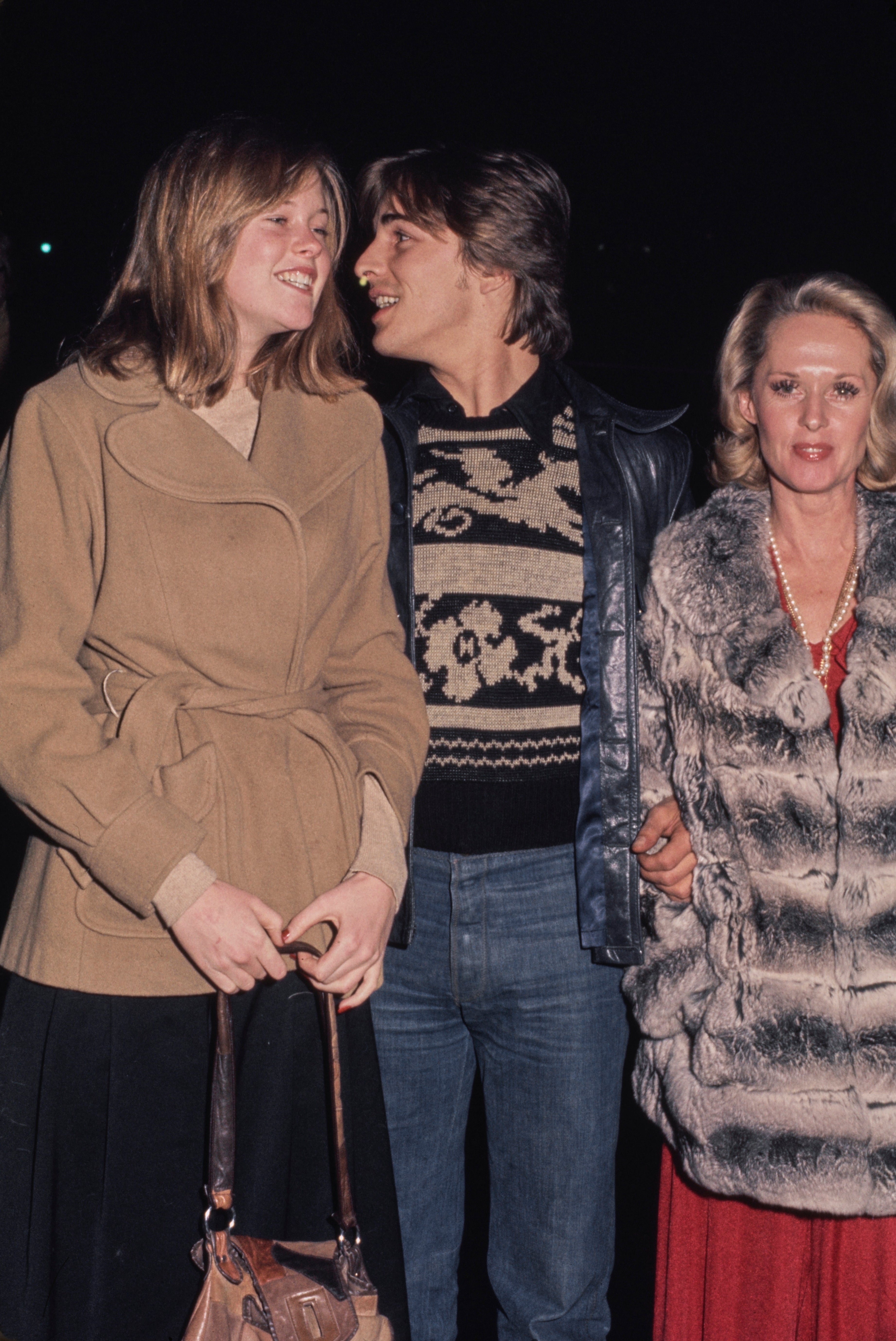 Melanie, Don, and Tippi radical successful semi-formal attire, walking unneurotic astatine nighttime outdoors