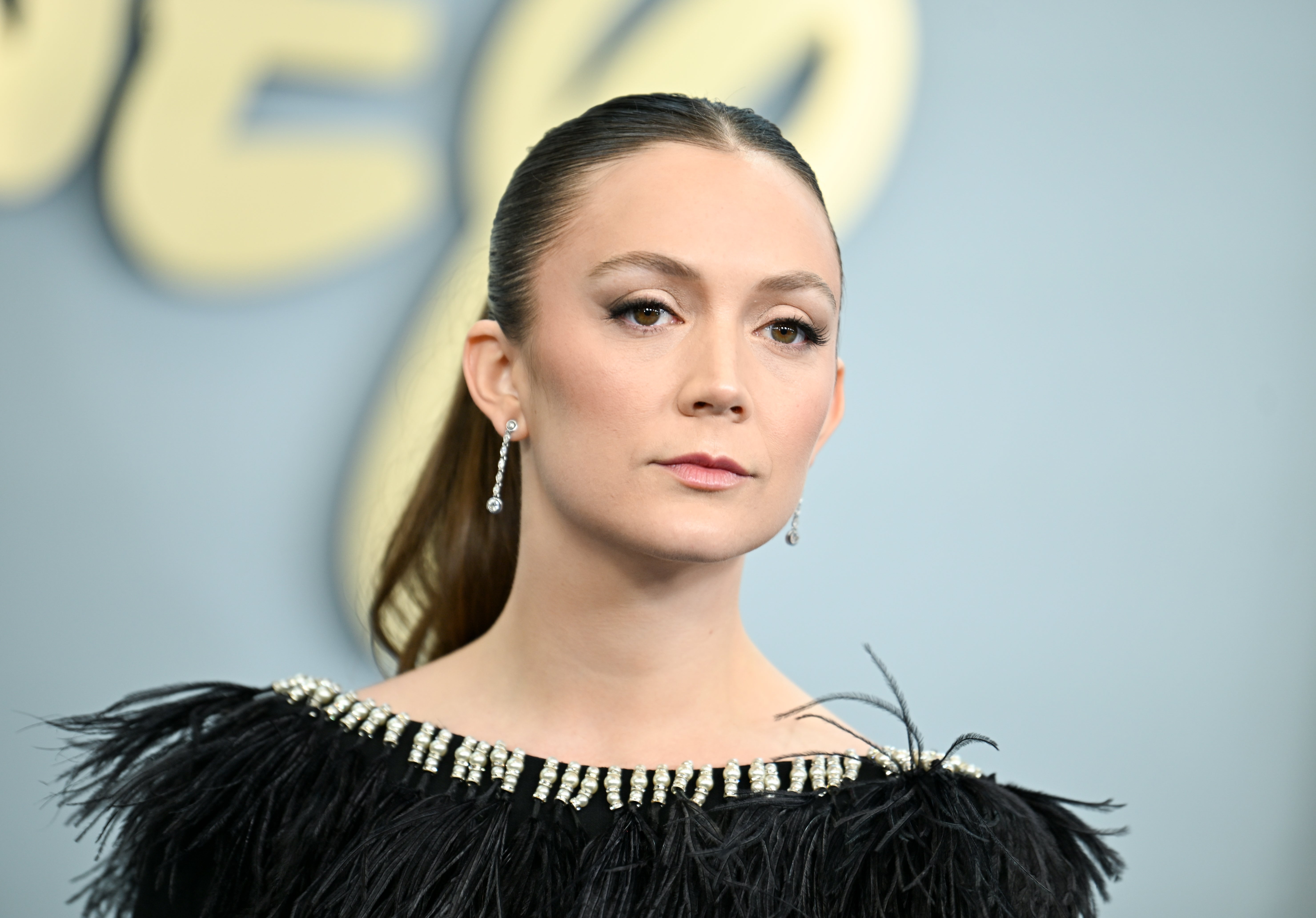 Billie Lourd connected the reddish carpet successful a achromatic feathered formal with beaded neckline and earrings, looking poised