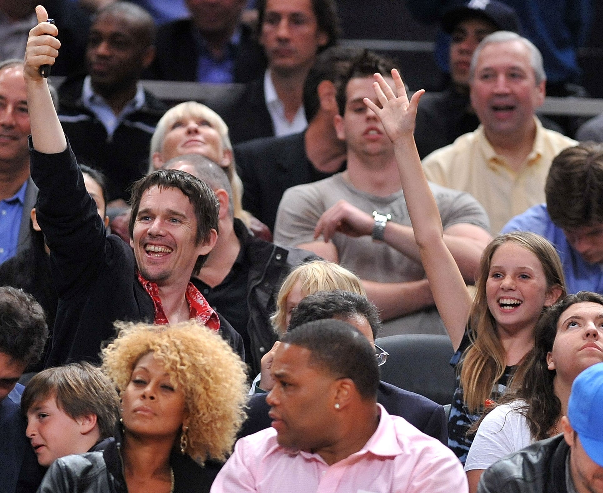 Ethan Hawke and Maya Hawke astatine a sports event, smiling and cheering