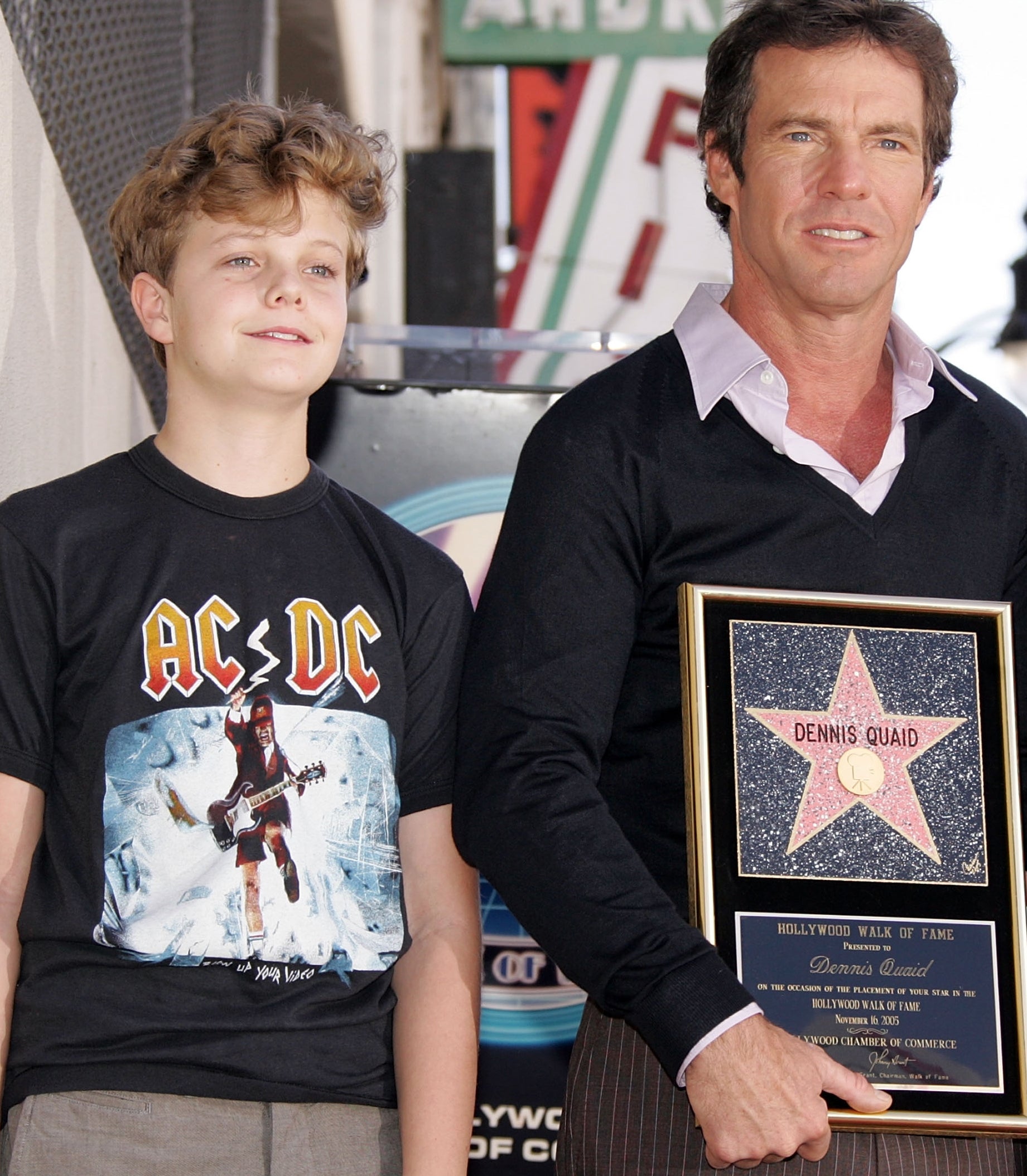 Dennis and Jack Quaid basal together, Dennis holding a Hollywood Walk of Fame prima plaque.