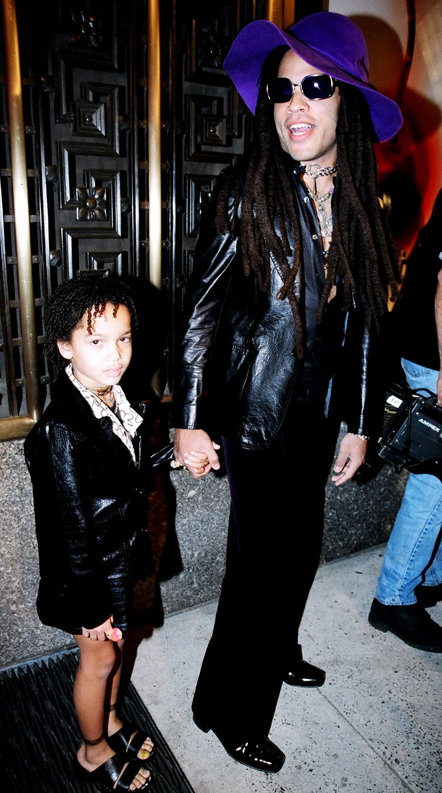 Lenny Kravitz successful a bold, wide-brimmed chapeau and leather outfit holds hands with a Zoe successful a akin leather jacket
