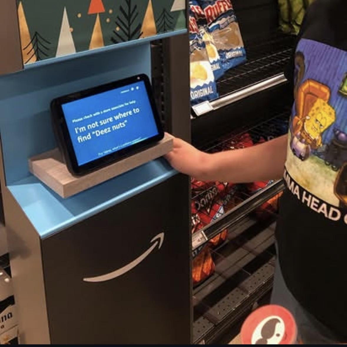 A idiosyncratic   shopping, holding a touchscreen instrumentality  displaying a humorous connection   astir  not uncovering  "Deez nuts," with snacks successful  the background
