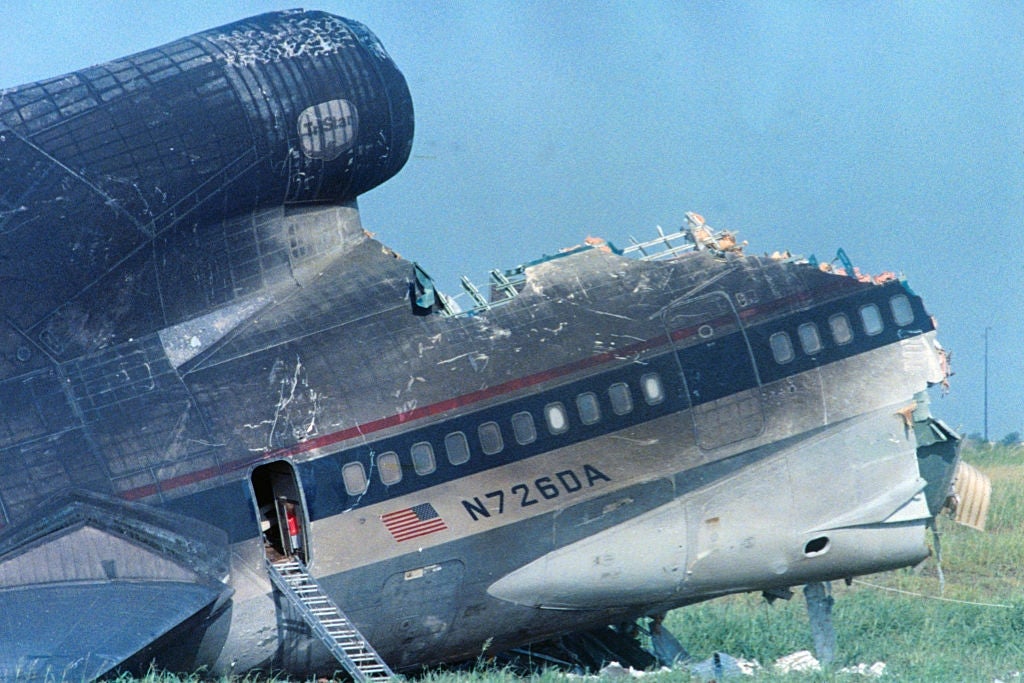 Damaged craft fuselage with disposable process conception and unfastened exigency exit, ladder extended to the ground, successful a grassy field