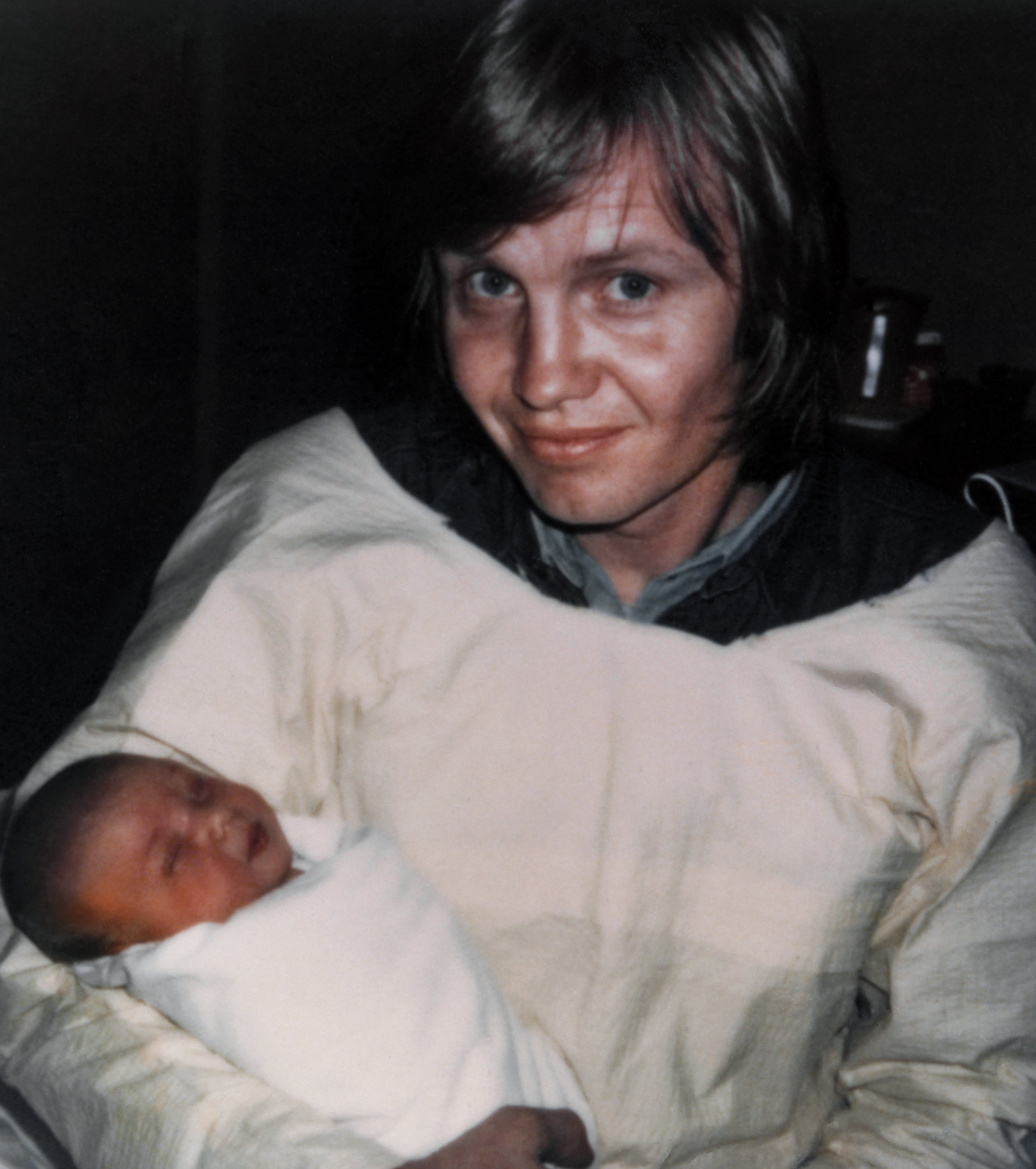 Jon Voight smiles mildly portion holding a newborn wrapped successful a blanket, some sitting connected a bed