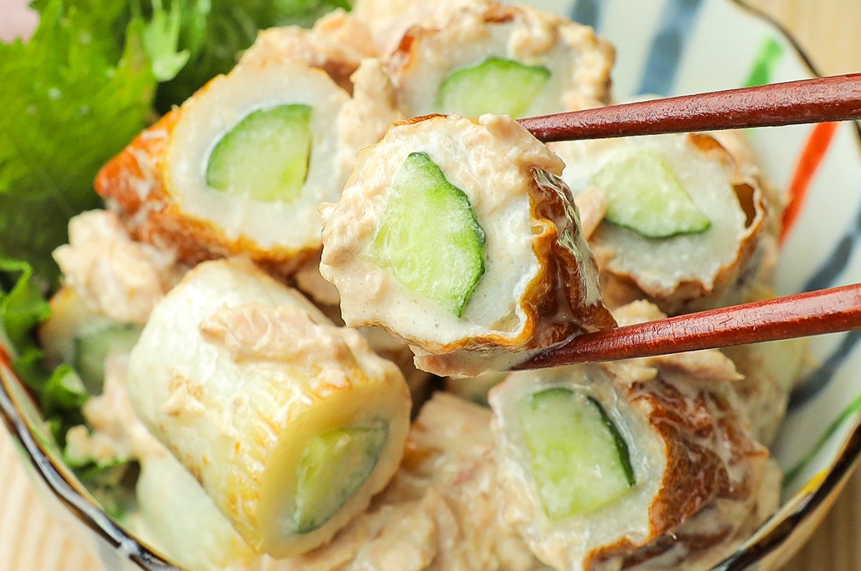 ちくわの中にきゅうりが詰められた料理が、ボウルに盛られている。箸で一つ持ち上げられている。