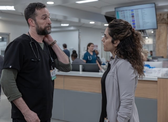 Two radical   successful  a infirmary  mounting  prosecute  successful  conversation. One wears scrubs and a stethoscope; the different   wears a laboratory  coat