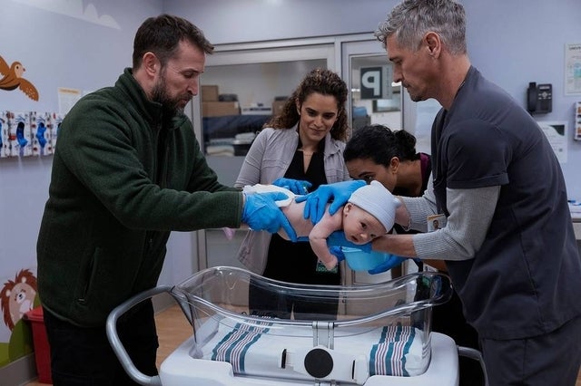 Four adults successful  a infirmary  mounting  cautiously  thin   to a babe  successful  an incubator