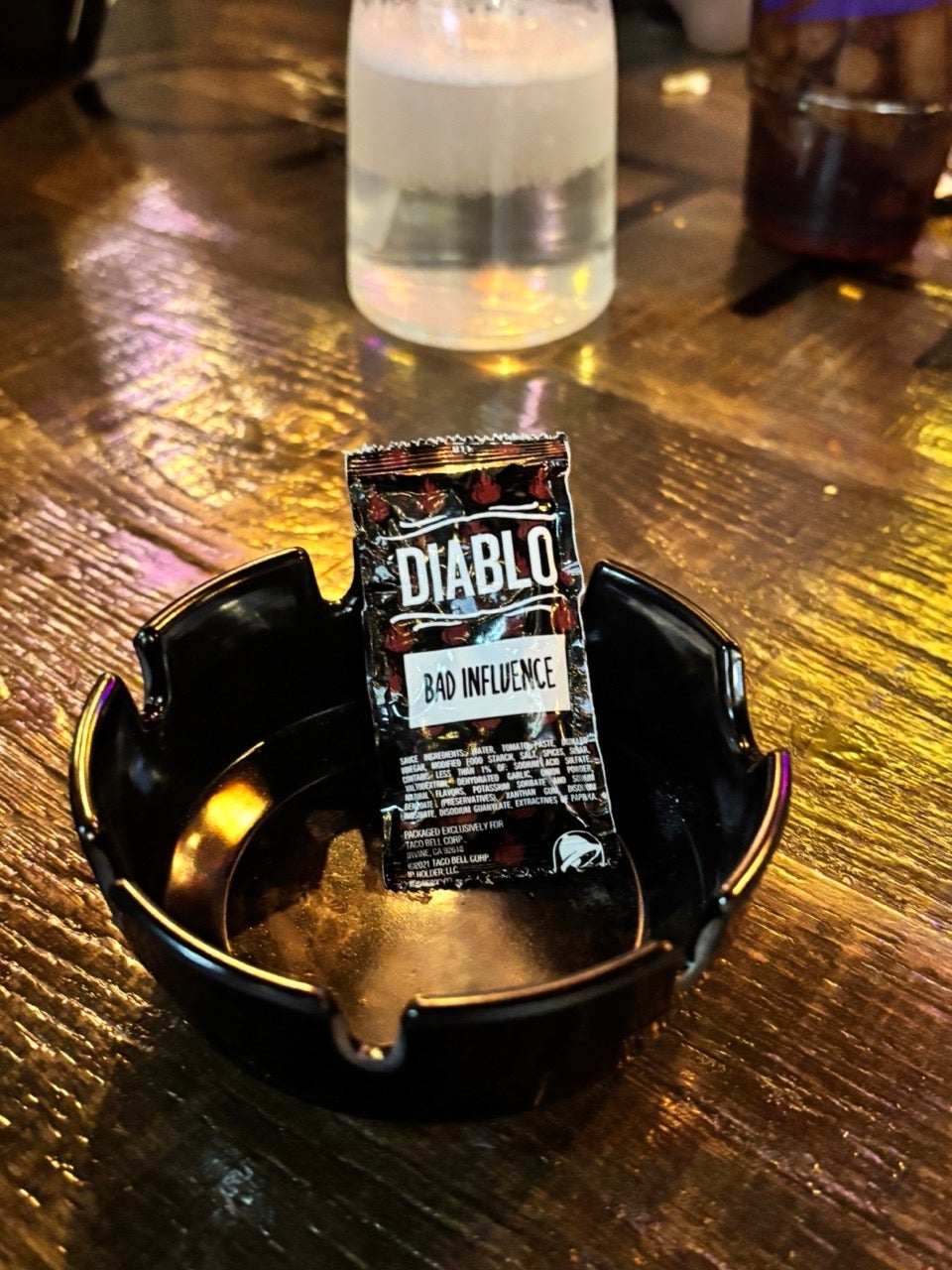 A tiny  "Diablo Bad Influence" packet is placed upright successful  an bare  ashtray connected  a woody  table
