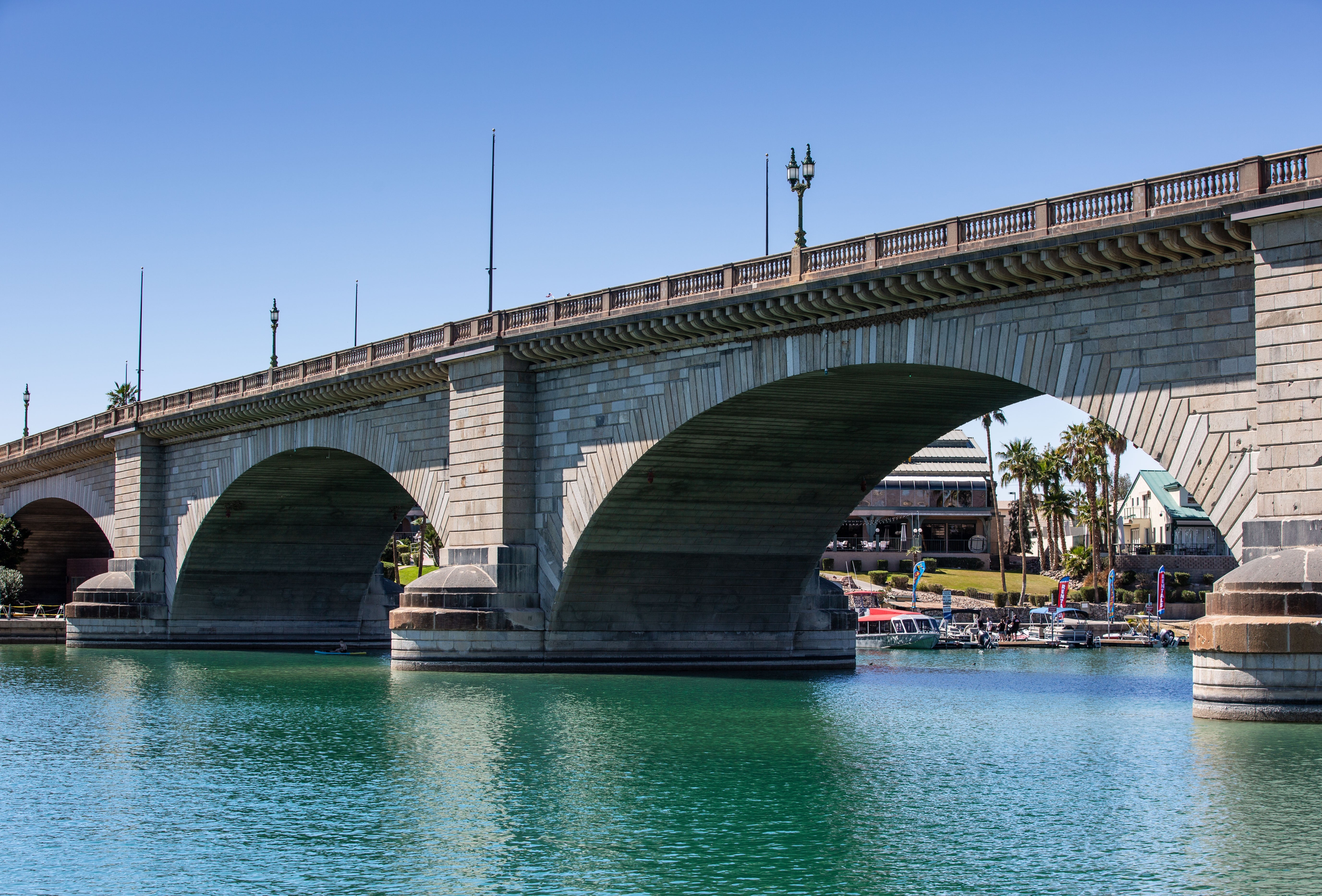 London Bridge implicit    a calm river, with arches reflecting connected  the water, and buildings and thenar  trees disposable   successful  the background