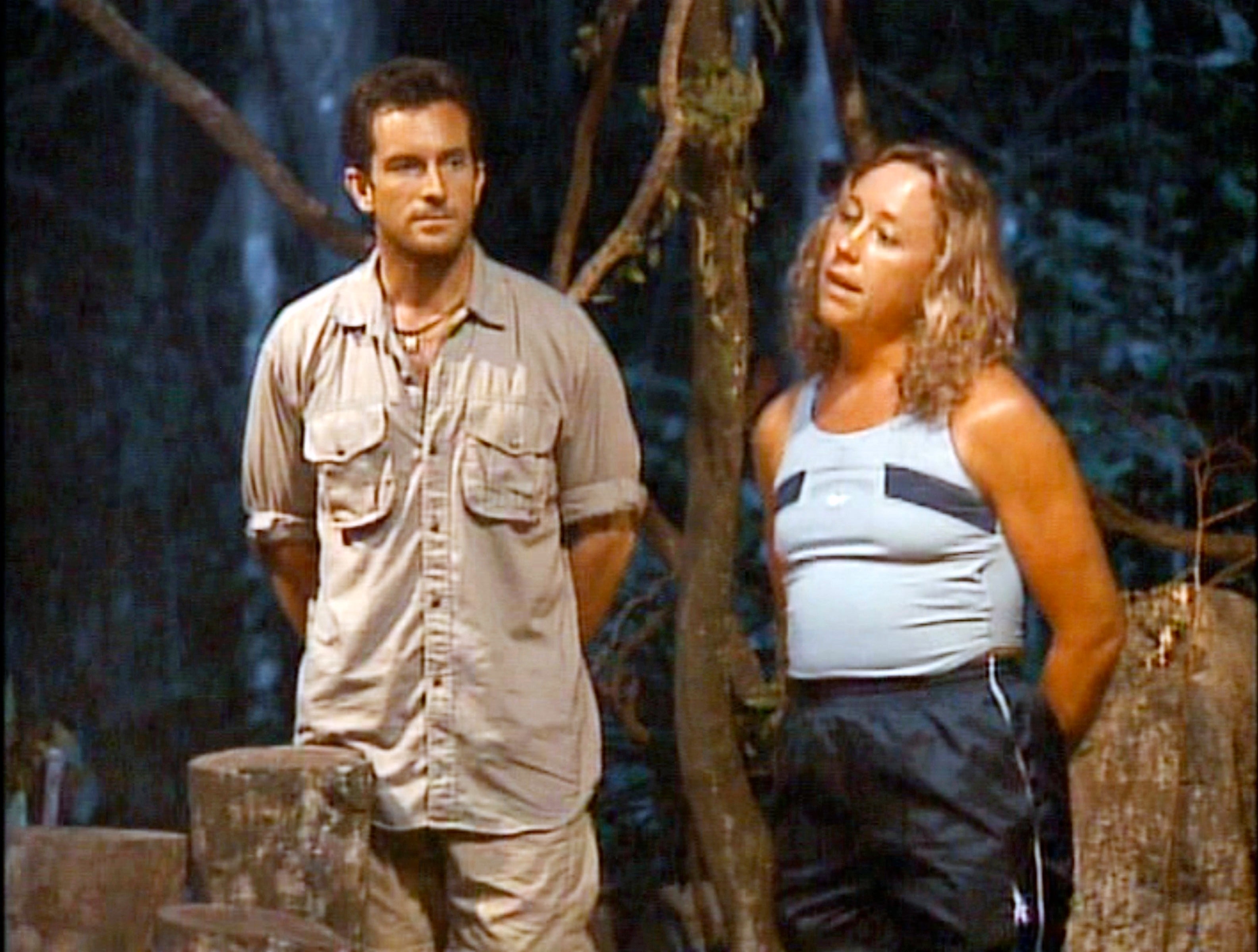 Two radical   lasting  successful  a jungle setting, 1  wearing a beige safari outfit and the different   successful  a vessel  apical  and pants, appearing to person  a conversation
