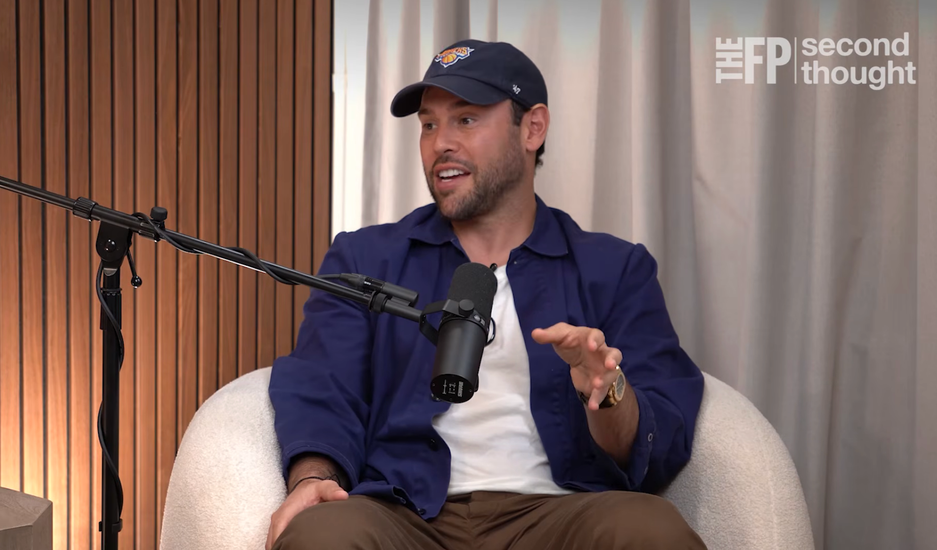 Person successful a casual outfit and headdress speaking into a microphone during a podcast interview