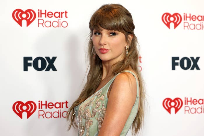 Person successful  elegant formal  astatine  iHeartRadio event, posing for photos. Background features iHeartRadio and FOX logos