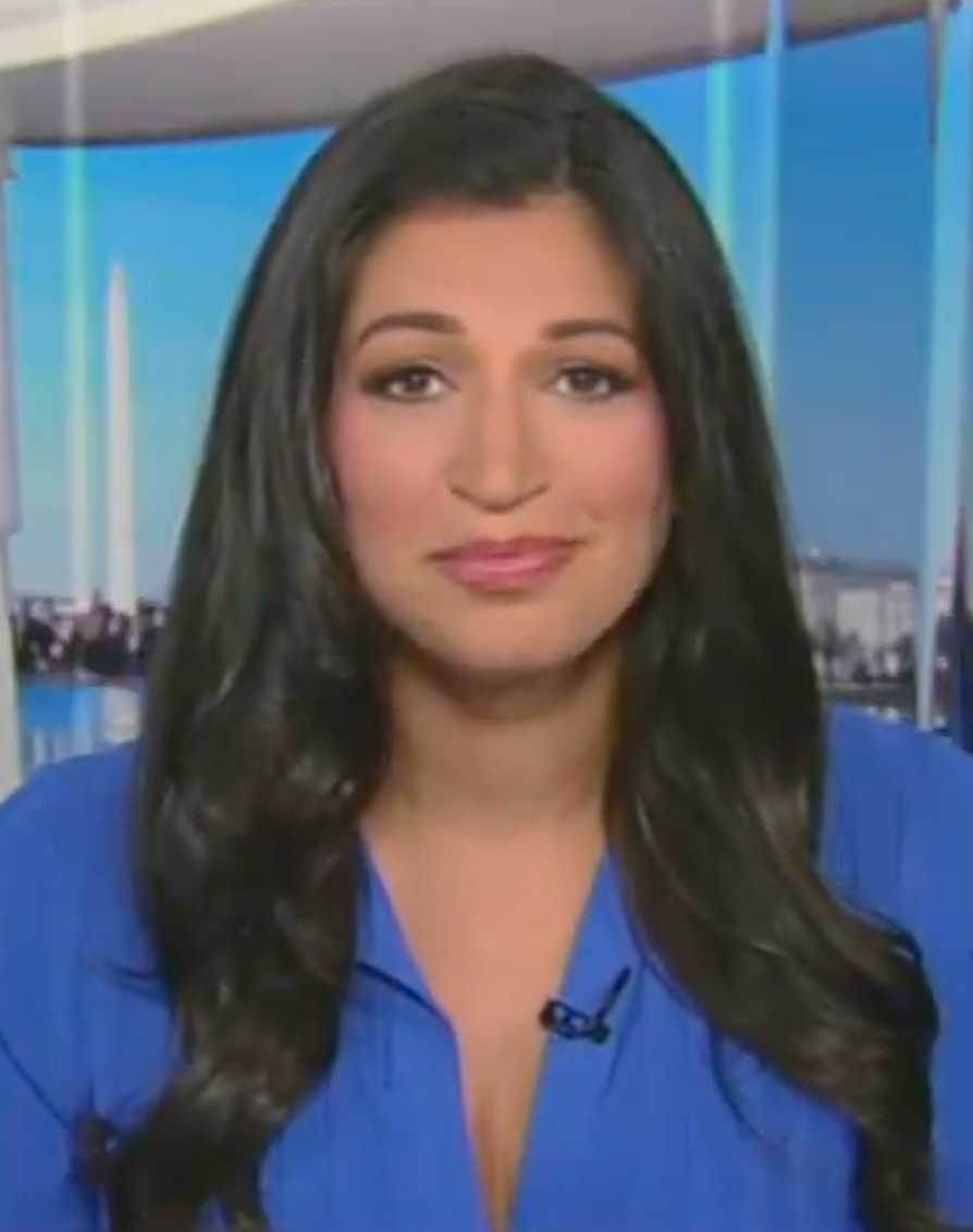 Person with agelong acheronian hair, wearing a bluish top, successful an indoor mounting with Washington Monument disposable successful the background