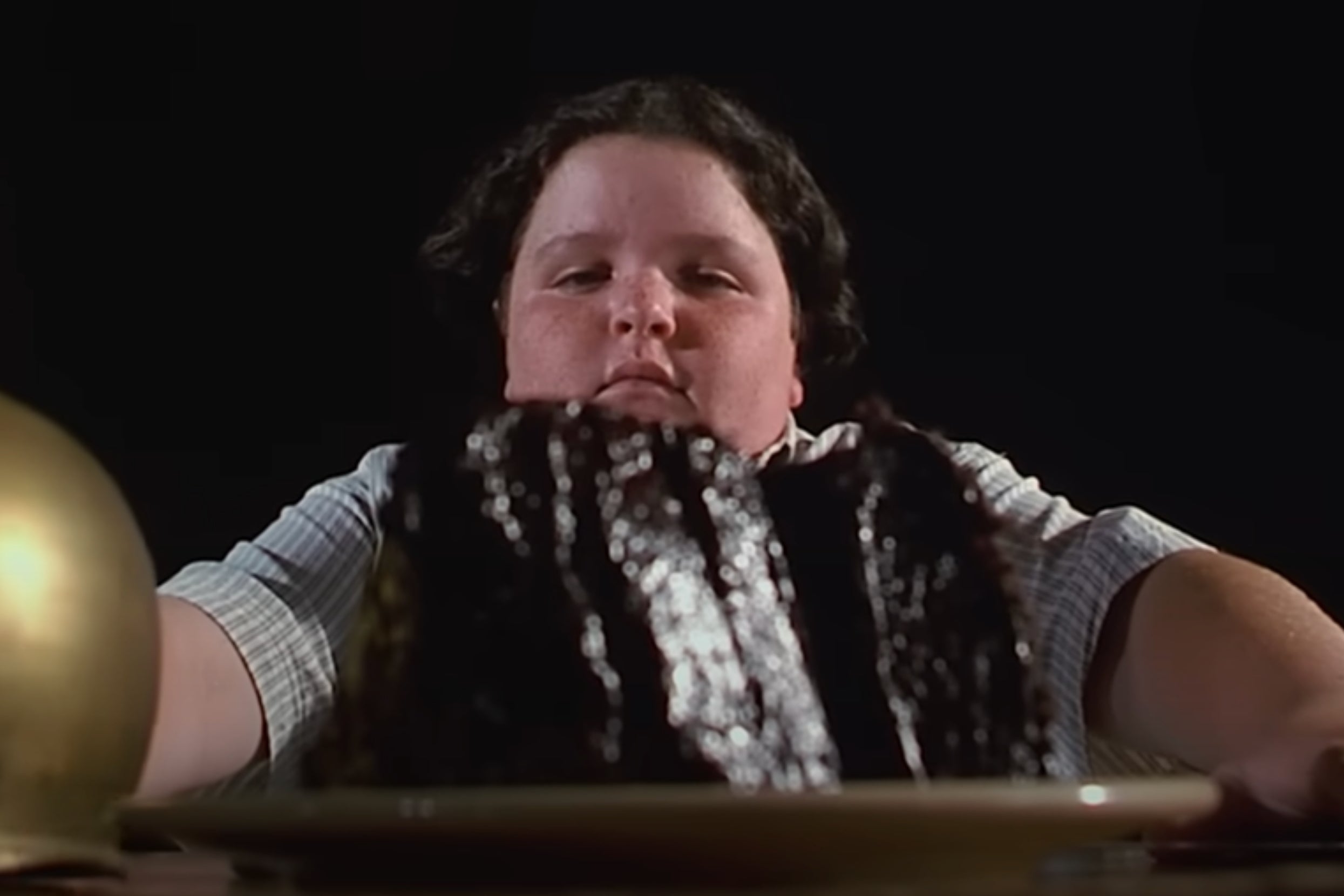 Bruce from Matilda sitting in front of a chocolate cake